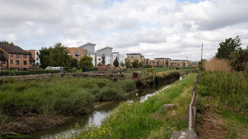 A small river with a city in the background.
