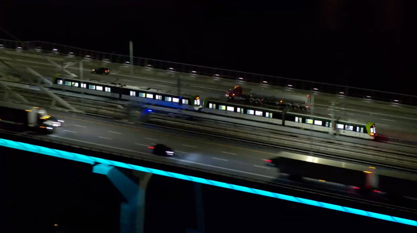 Samuel de Champlain bridge at night showing train crossing alongside vehicles