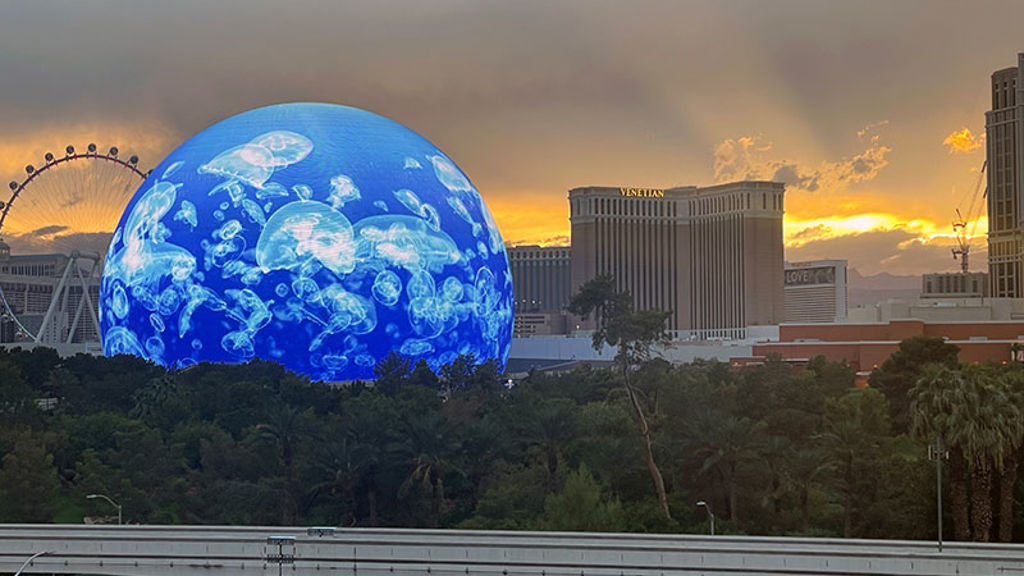 A large globe in front of a city.