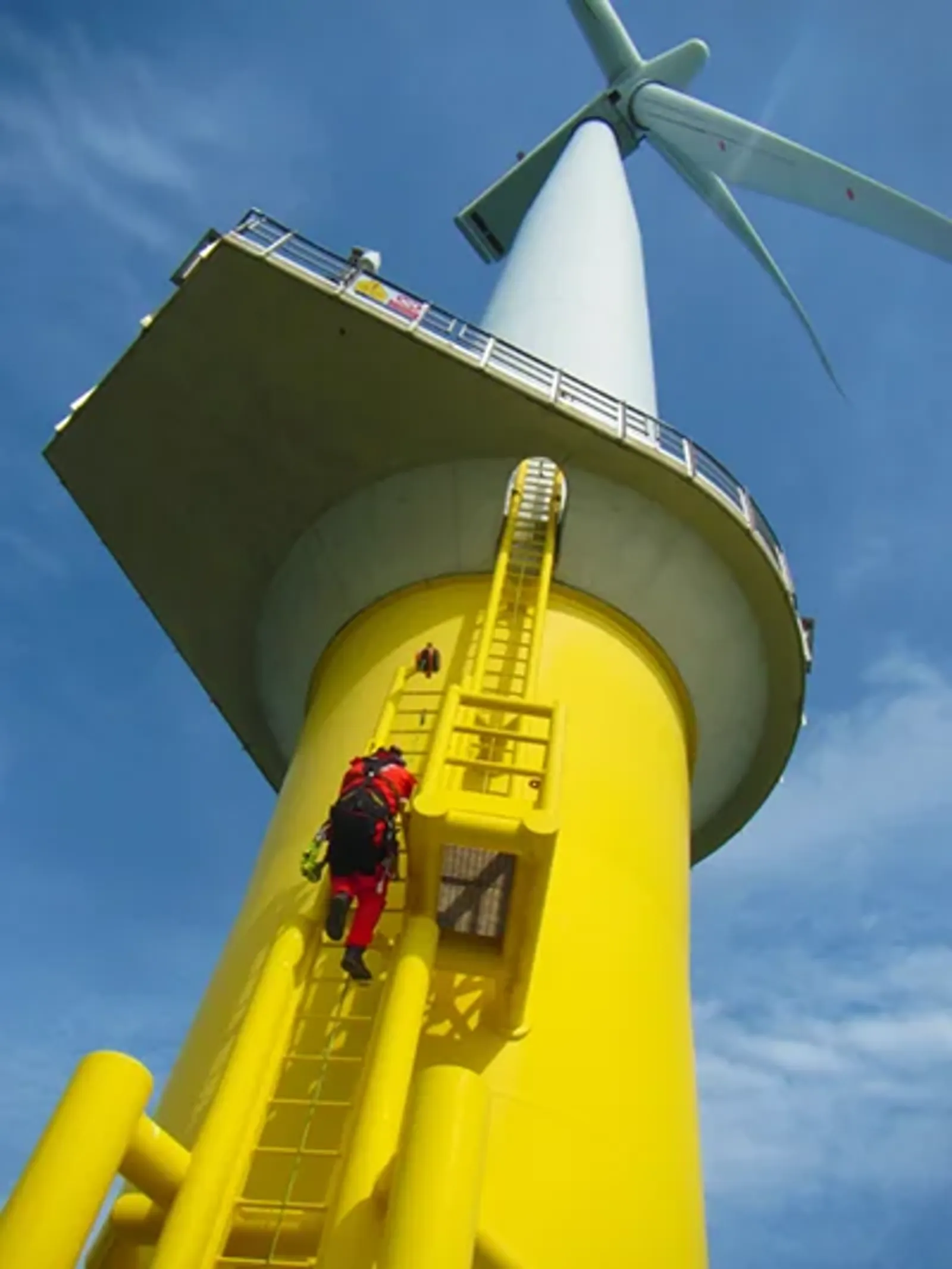 Man climbing on to an offshore wind turbine base