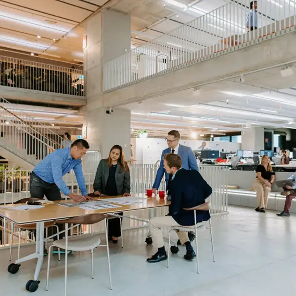 People sitting at tables in a large room with many people.
