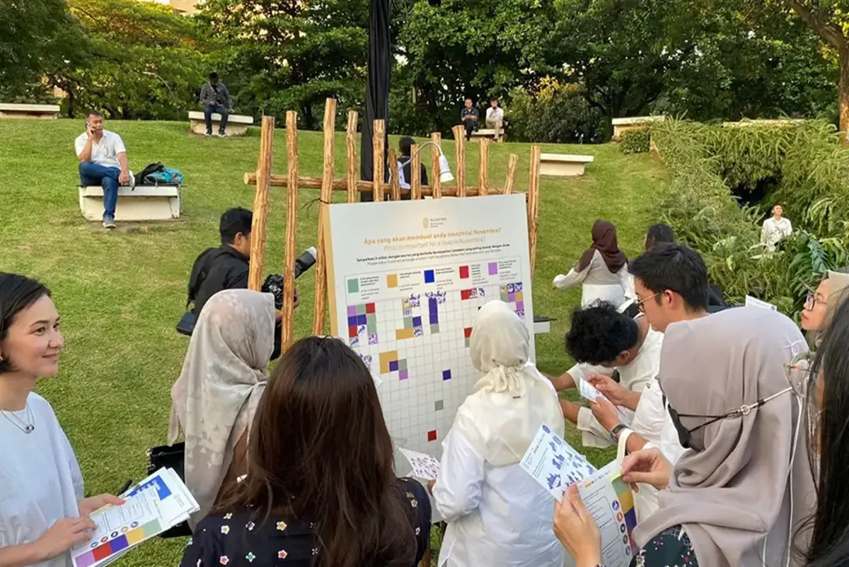 A group of people in a park taking part in a workshop